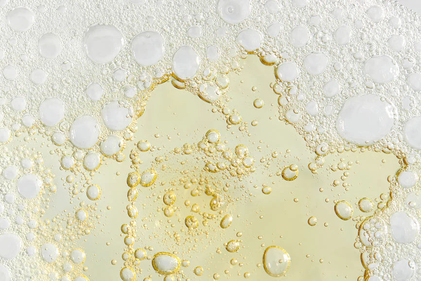 Close-up of Dr. Zenovias Vitamin C Serum mixture with bubbles on a light background