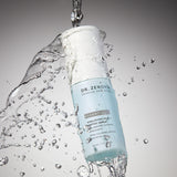 Dr. Zenovia Hyaluronic Acid + Peptide Serum bottle in motion with water splash, highlighting hydration benefits